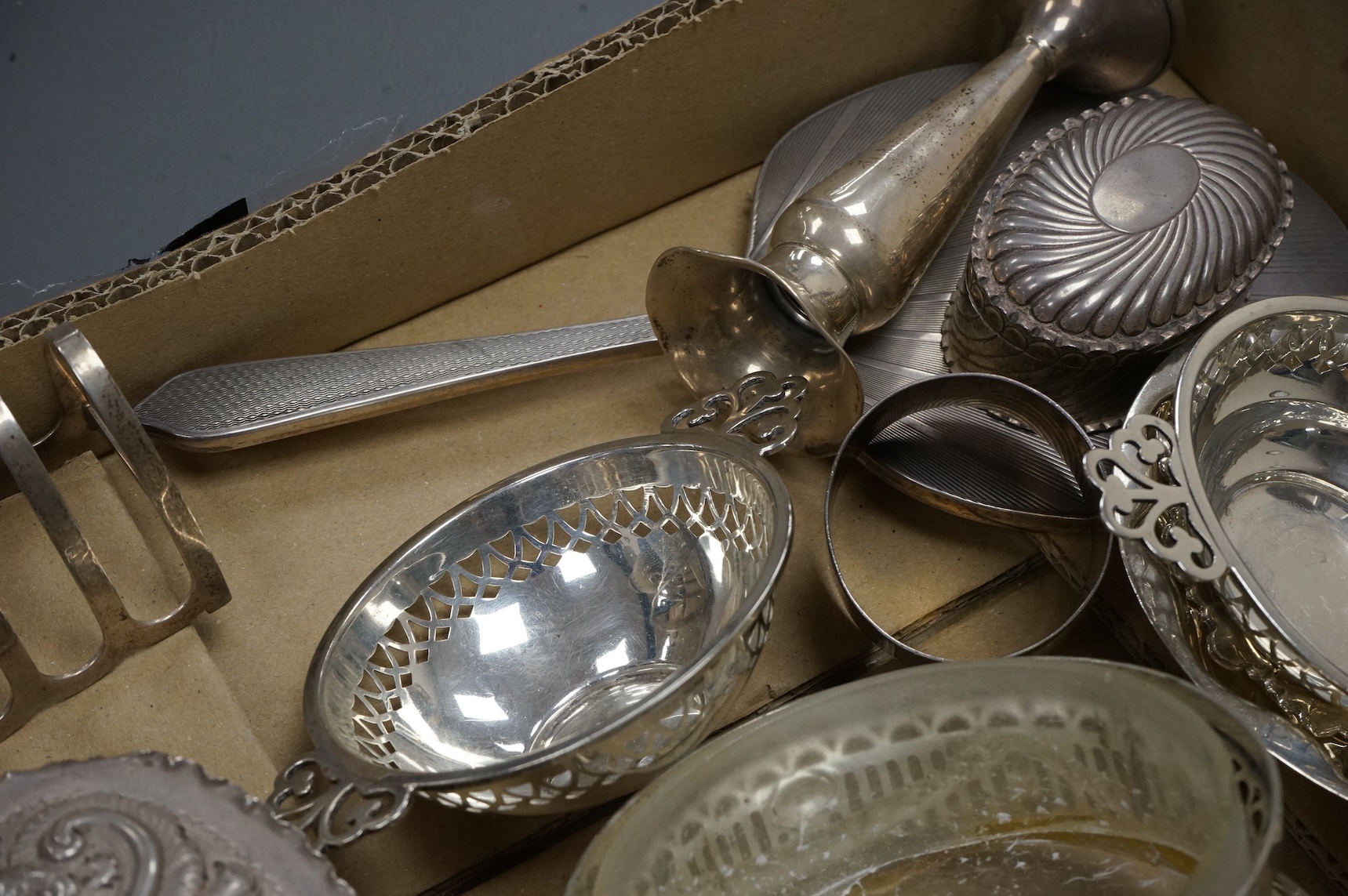 A group of small collectable silver including a late Victorian heart shaped trinket box, Chester, 1899, length 92mm (a.f.), a coaster, toast rack, spill vase, small trinket box, a pair of two handled dishes, napkin ring,